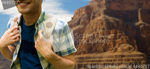 Image of close up of man with backpack over grand canyon