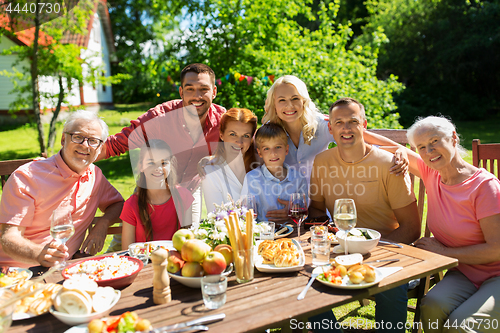 Image of happy family having dinner or summer garden party