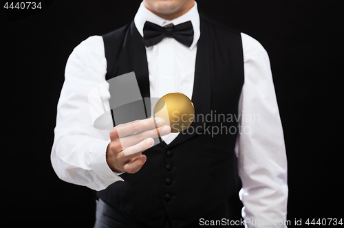 Image of close up of casino dealer holding golden coin