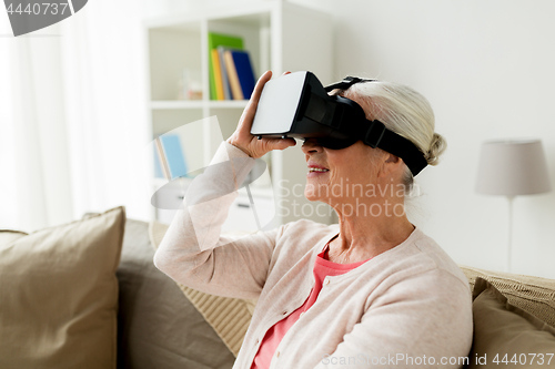 Image of old woman in virtual reality headset or 3d glasses