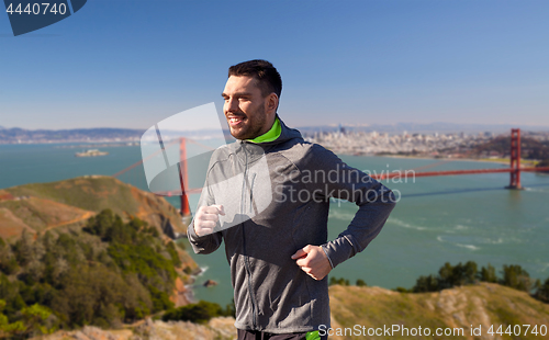 Image of happy young man running over golden gate bridge