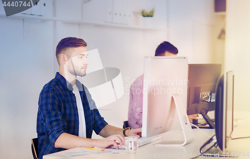 Image of creative man or student with computer at office