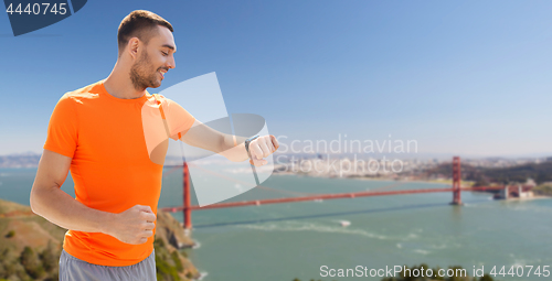 Image of man with fitness tracker over golden gate bridge