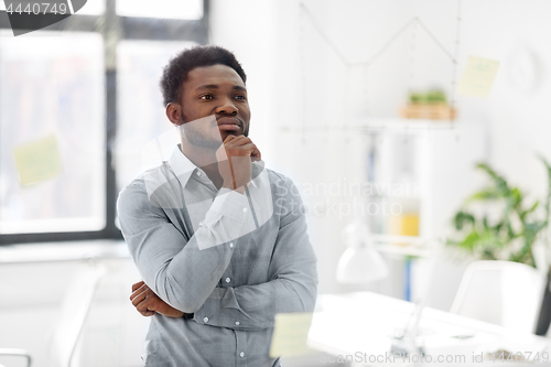 Image of businessman looking at glass board at office