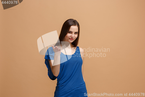 Image of The happy woman standing and smiling against pastel background.