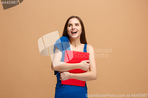 Image of Businesswoman hugging laptop on pastel studio