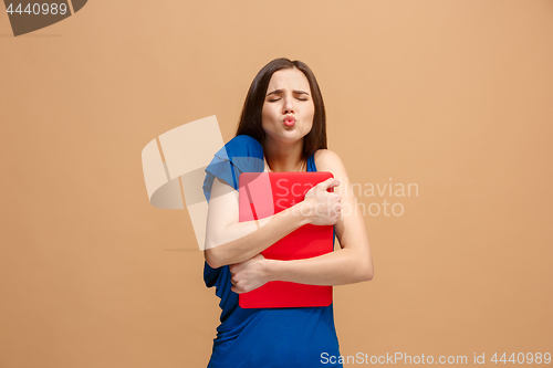 Image of Businesswoman hugging laptop on pastel studio