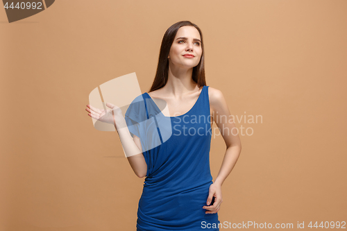 Image of The happy woman standing and smiling against pastel background.