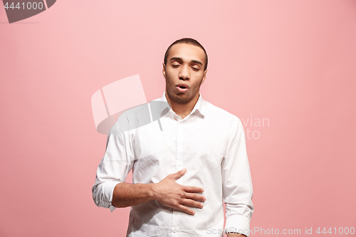 Image of The happy business man standing and smiling against pink background.