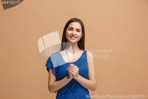 Image of The happy woman standing and smiling against pastel background.