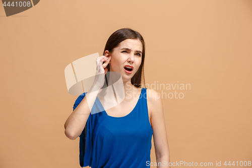 Image of The Ear ache. The sad woman with headache or pain on a pastel studio background.