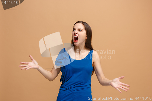 Image of The young emotional angry woman screaming on pastel studio background