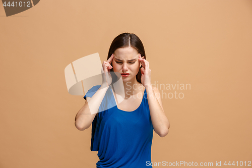 Image of Woman having headache. Isolated over pastel background.