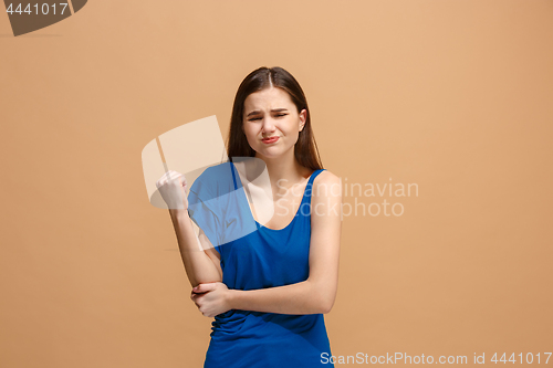 Image of The elbow ache. The sad woman with elbow ache or pain on a pastel studio background.