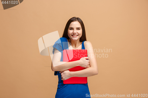 Image of Businesswoman hugging laptop on pastel studio