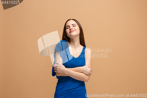 Image of The happy business woman standing and smiling against pastel background.