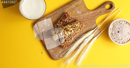 Image of Cereal bars and oats on wooden board