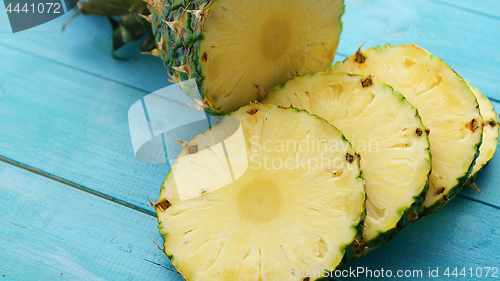 Image of Slices of pineapple on blue wood