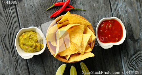 Image of Served nachos with sauces on table