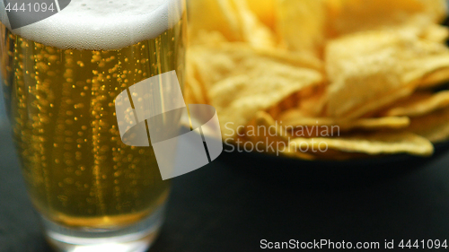 Image of Glass of beer and nacho chips