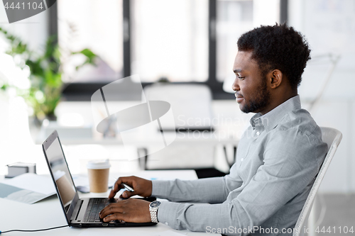 Image of african american businessman with laptop at office