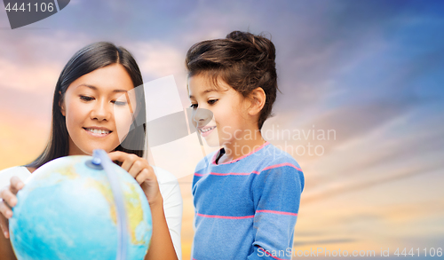 Image of happy mother and daughter with globe over sky