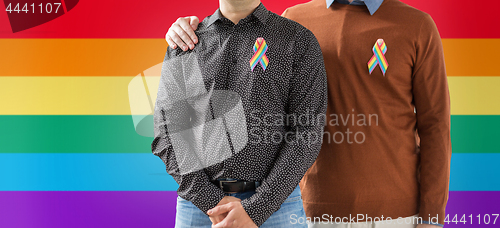 Image of close up of couple with gay pride rainbow ribbons