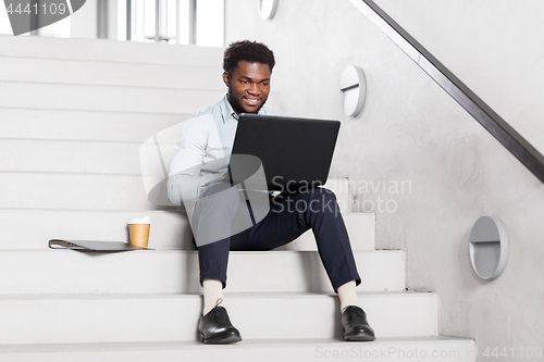 Image of african american businessman with laptop at office