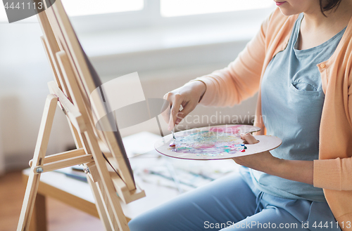 Image of artist with palette knife painting at art studio