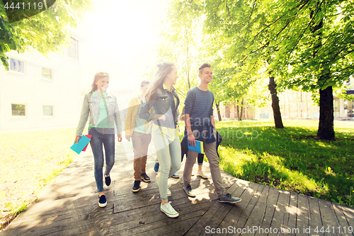 Image of group of happy teenage students walking outdoors