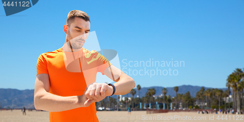 Image of man with fitness tracker training outdoors