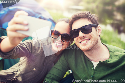 Image of couple of travelers taking selfie by smartphone