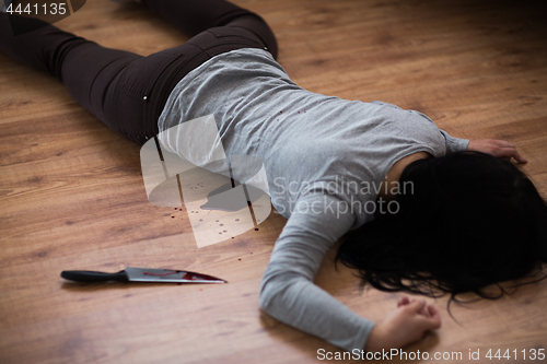 Image of dead woman body lying on floor at crime scene