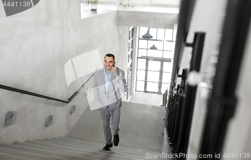 Image of businessman calling on smartphone at office