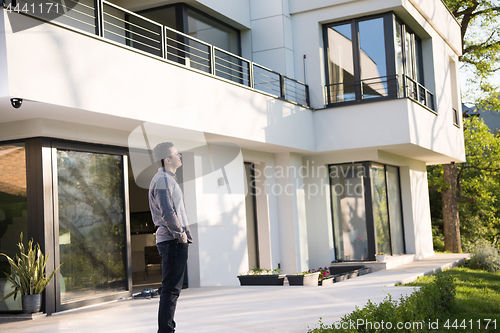 Image of man in front of his luxury home villa