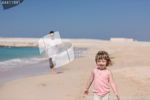 Image of mother and daughter running on the beach