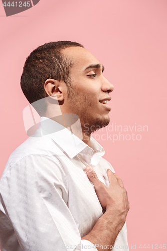 Image of The happy businessman standing and smiling against pink background.