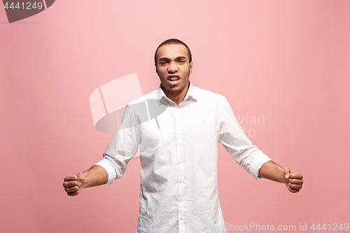 Image of The young emotional angry man screaming on pink studio background