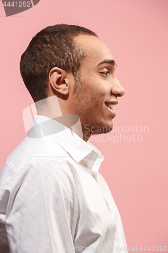 Image of The happy businessman standing and smiling against pink background.