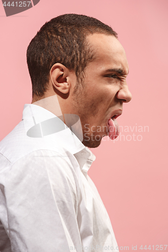 Image of Young man with disgusted expression repulsing something, isolated on the pink