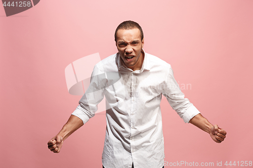 Image of The young emotional angry man screaming on pink studio background