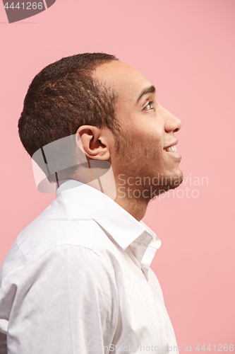 Image of The happy businessman standing and smiling against pink background.