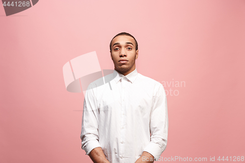 Image of Let me think. Doubtful pensive man with thoughtful expression making choice against pink background