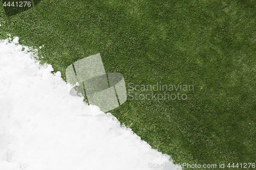 Image of Meeting snow on green grass close up - between winter and spring concept background