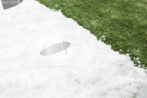 Image of Meeting snow on green grass close up - between winter and spring concept background