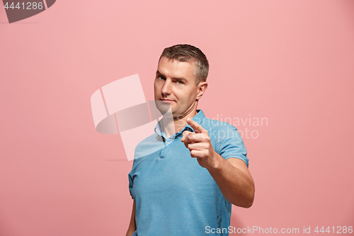 Image of The serious business man point you and want you, half length closeup portrait on pink background.
