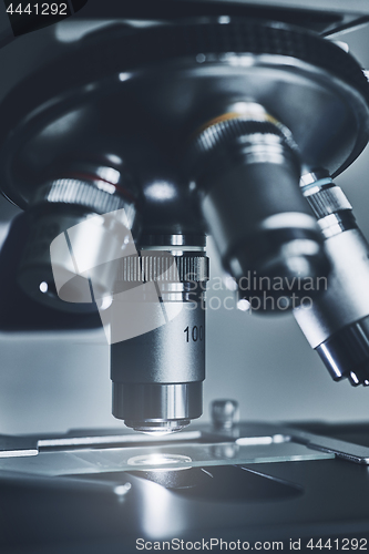 Image of Modern microscope with metal lens at laboratory.