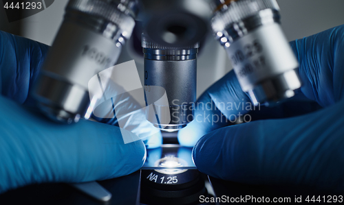 Image of Scientist hands with microscope