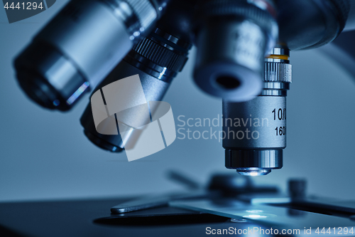 Image of Modern microscope with metal lens at laboratory.