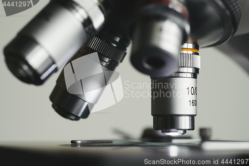 Image of Modern microscope with metal lens at laboratory.